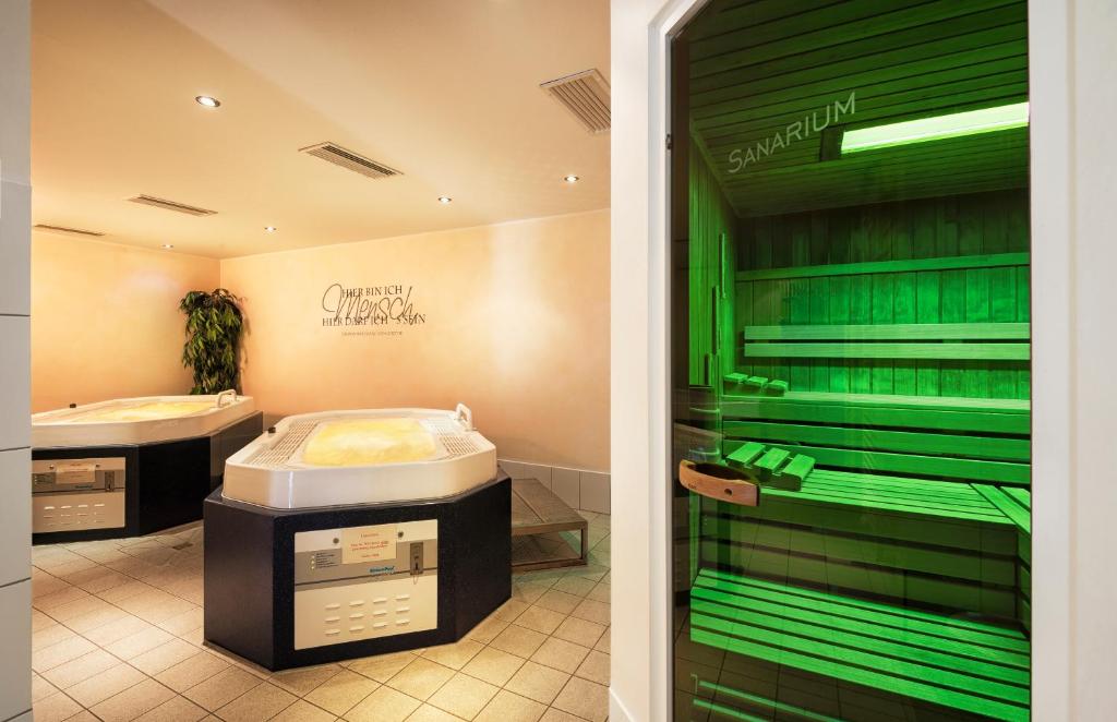 a bathroom with green walls and a sink at Strandhotel Juister Hof in Juist