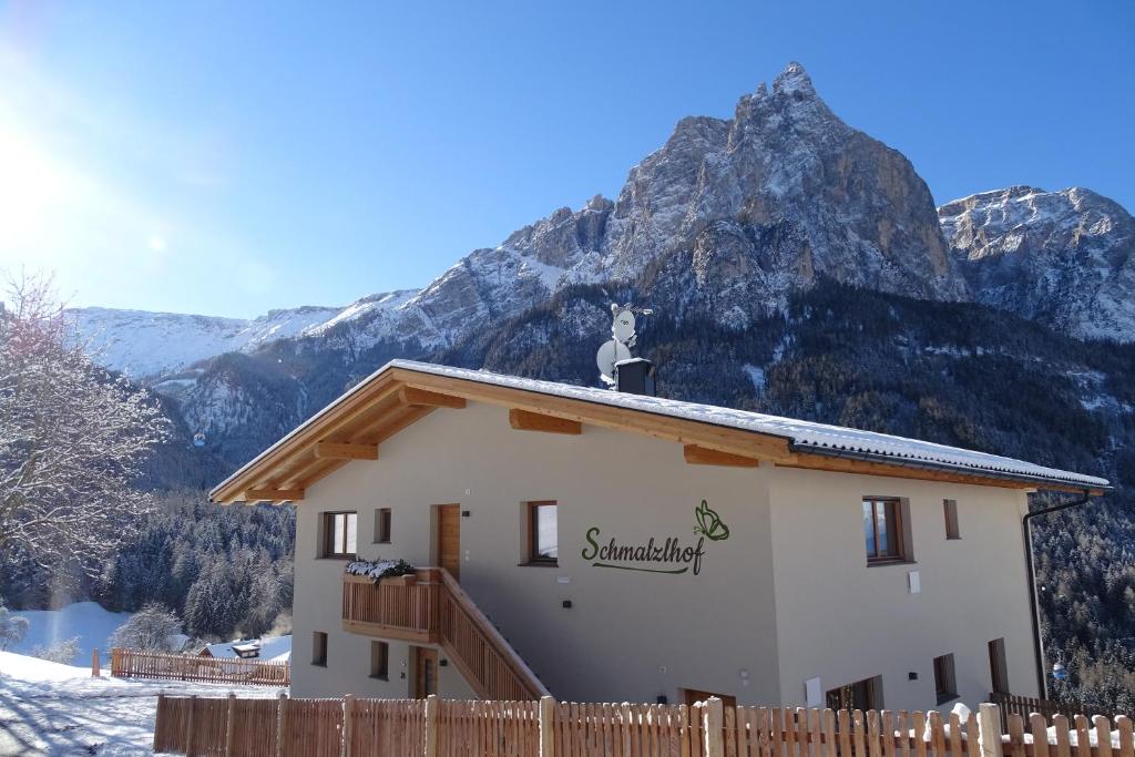 uma casa com uma montanha ao fundo em Schmalzlhof em Siusi