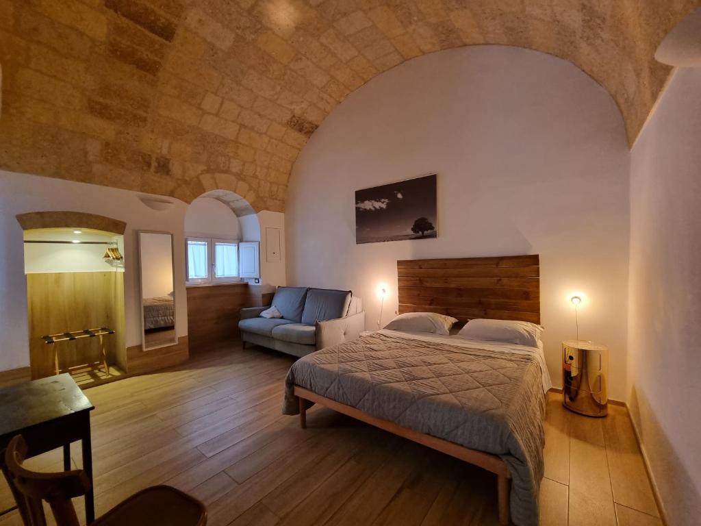 a bedroom with a bed and a couch in a room at B&B Novecento Italiano in Altamura