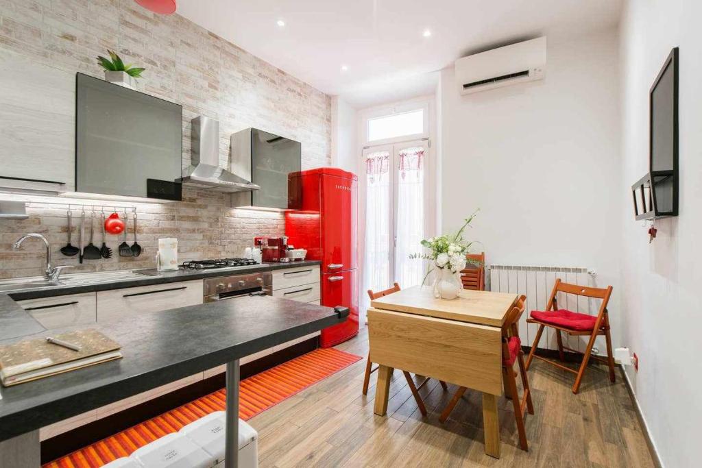 a kitchen with a red refrigerator and a table at Little House in the centre Nettuno in Nettuno