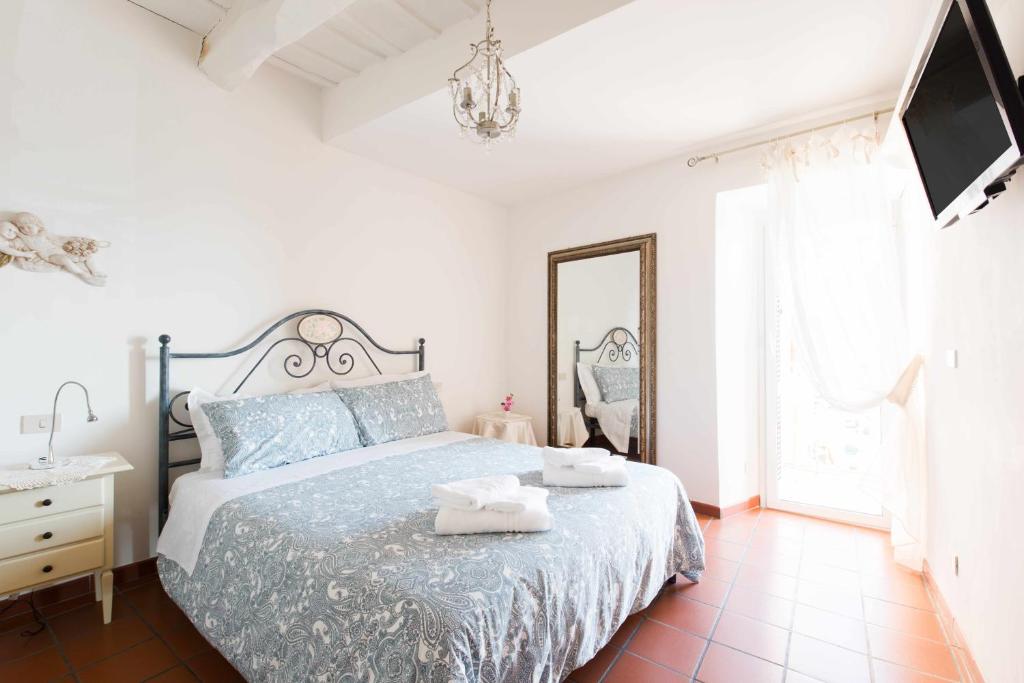 1 dormitorio con cama, espejo y TV en Little Medieval House Nettuno, en Nettuno