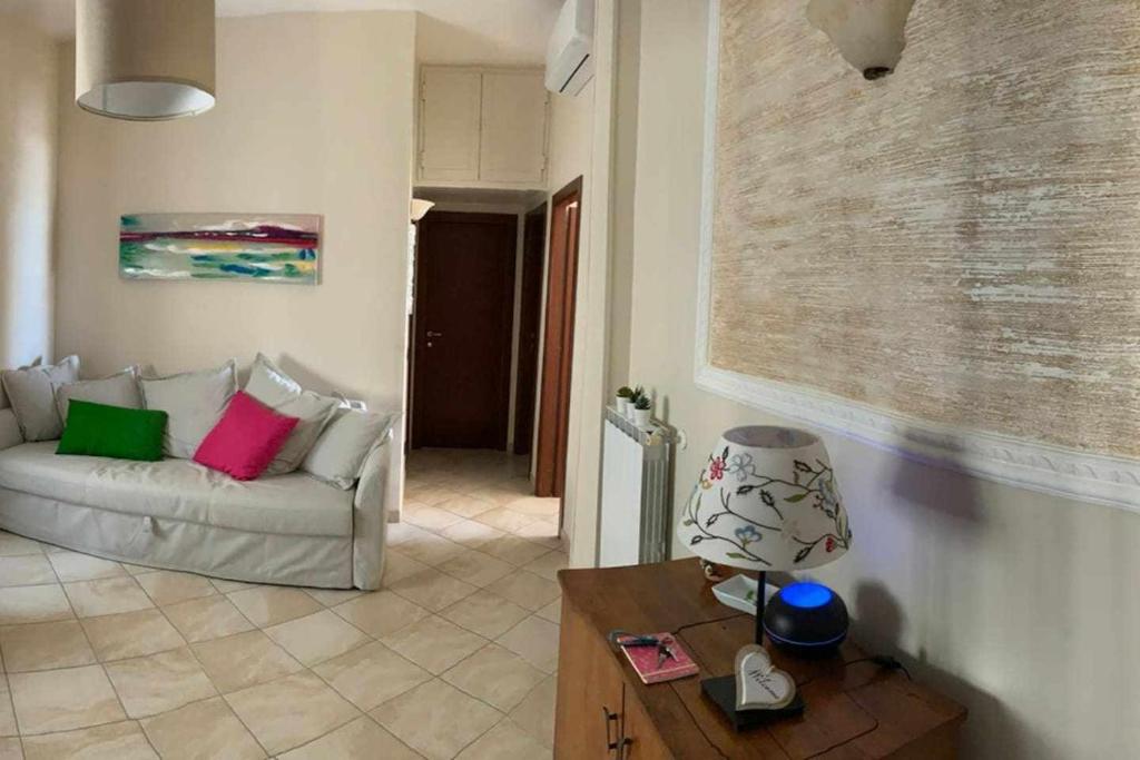 ein Wohnzimmer mit einem weißen Sofa und einem Tisch in der Unterkunft Appartamento sul porto Nettuno in Nettuno