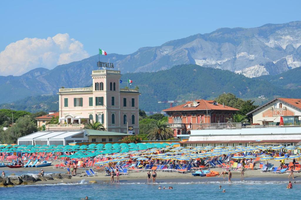 une plage avec un groupe de personnes sur la plage dans l'établissement Hotel Italia, à Marina di Massa