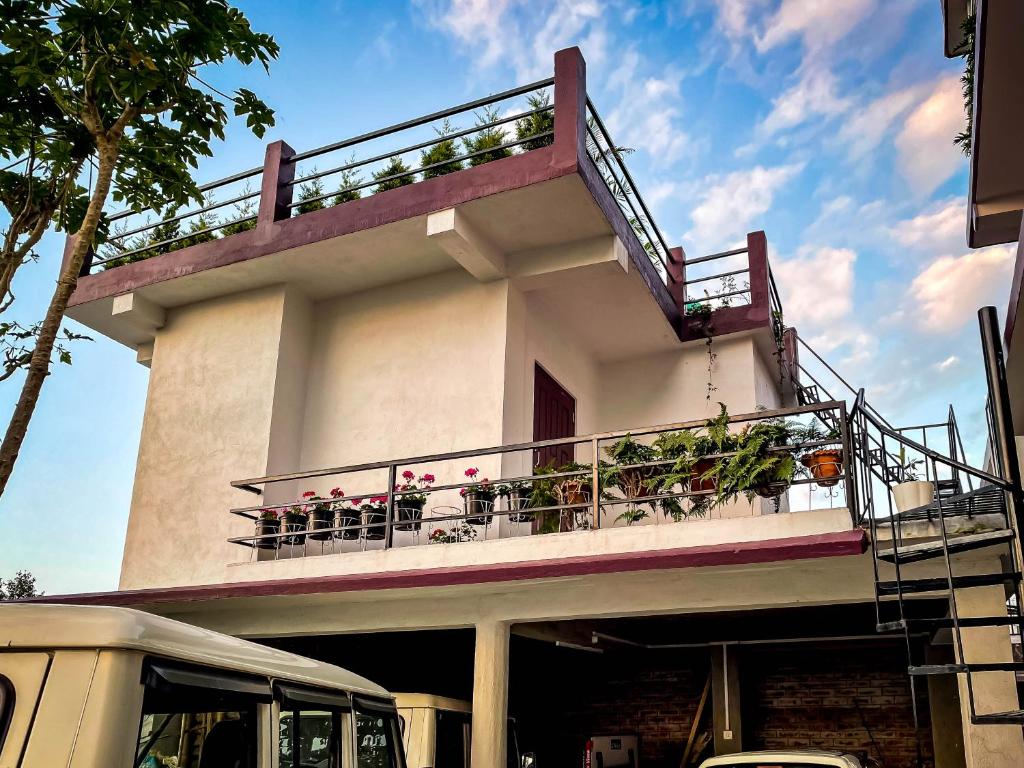 a building with a balcony with plants on it at Abu Homestay in Kohīma