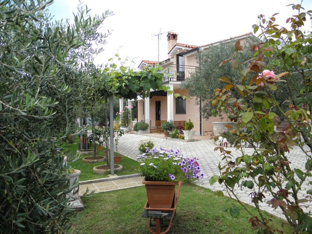 a house with a garden with flowers in the yard at Apartments Mirjana in Vrsar