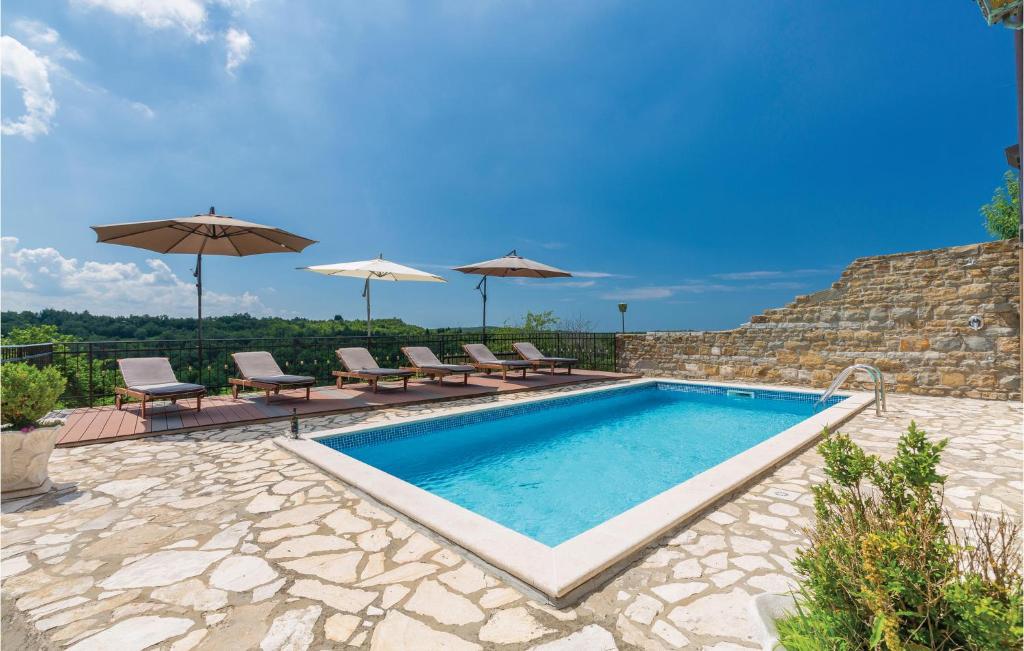 basen z leżakami i parasolami na patio w obiekcie Gorgeous Home In Momjan With Heated Swimming Pool w mieście Momjan