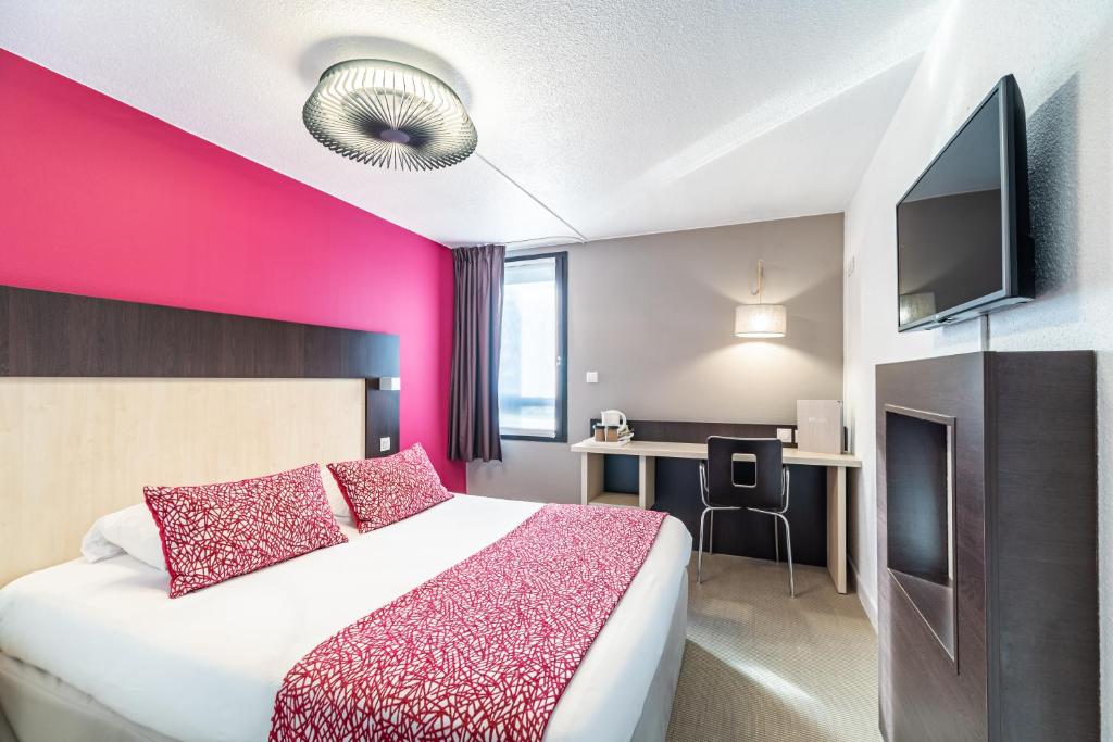 a hotel room with a bed and a pink wall at KYRIAD ROUEN NORD - Mont Saint Aignan in Mont-Saint-Aignan