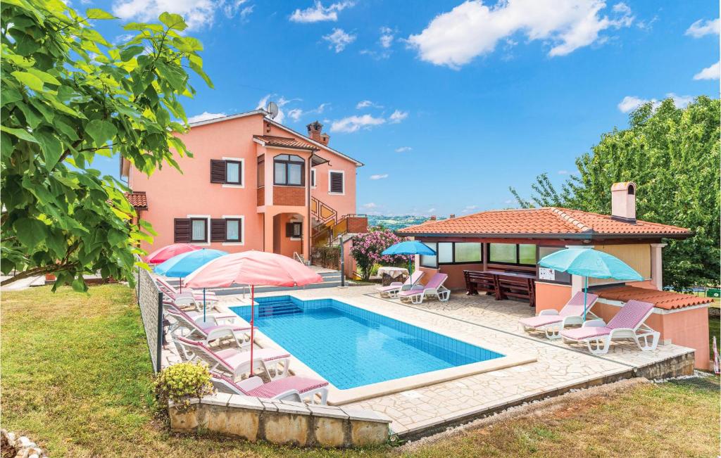a villa with a swimming pool and a house at Awesome Home In Labin With 6 Bedrooms, Wifi And Outdoor Swimming Pool in Vinež