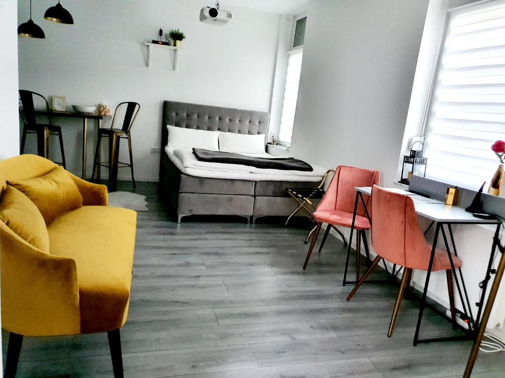 een kamer met een bed en stoelen en een tafel bij CITYLIFE Apartments Osnabrück mit E-Ladesäule in Osnabrück