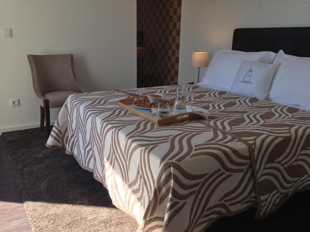 a hotel room with a bed with a tray of food on it at Casa Dona Maria Luiza in Torre de Moncorvo