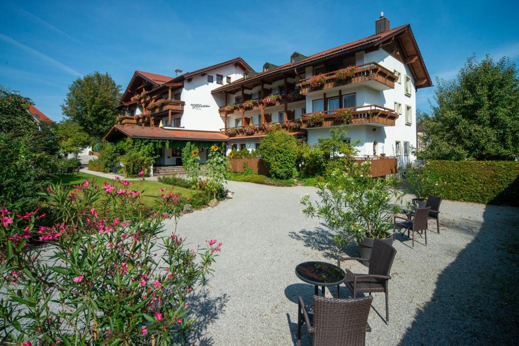 ein Gebäude mit Stühlen und Blumen davor in der Unterkunft Hotel Filser in Füssen