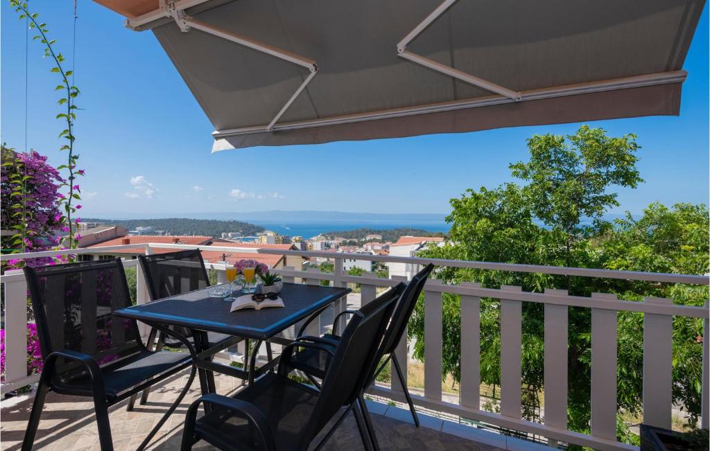 una mesa azul y sillas en el balcón en Nice Apartment In Makarska With Kitchen, en Makarska