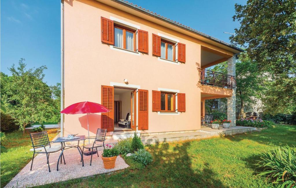 a house with a table and chairs in a yard at Apartment Labin Presika Ii in Labin