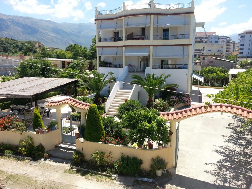 a large white house with a garden in front of it at Apartments Rudi in Orikum