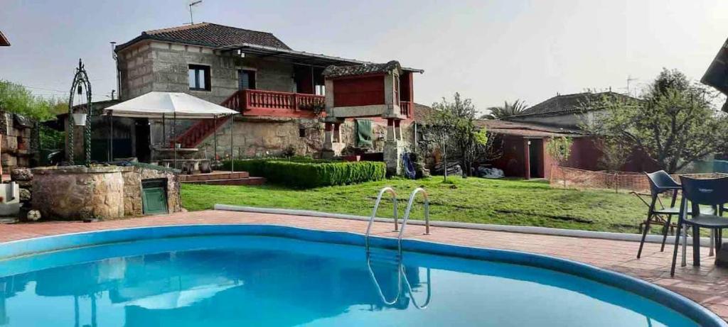 a swimming pool in front of a house at ALOJAMIENTO ENTERO CON PISCINA Y JARDIN. in Ourense