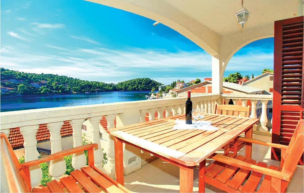 a wooden table on a balcony with a view of the water at Amazing Apartment In Smokvica With House Sea View in Brna