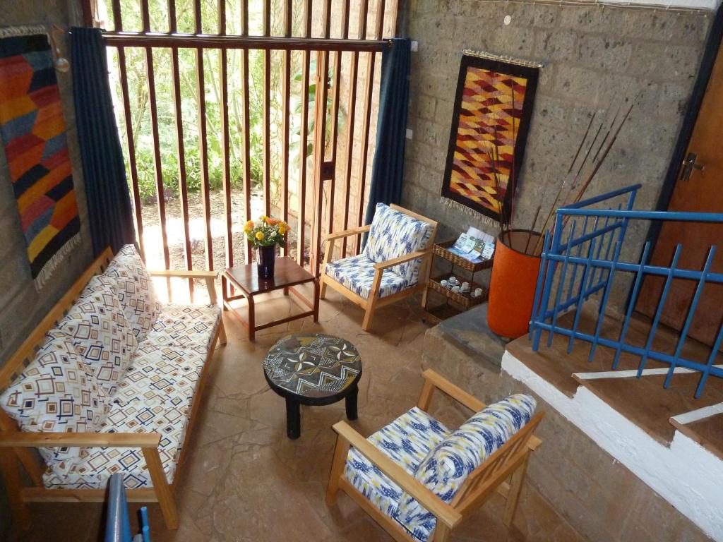 a balcony with two chairs and a table and a table at Villa Rock Stop Falls Gigiri in Nairobi
