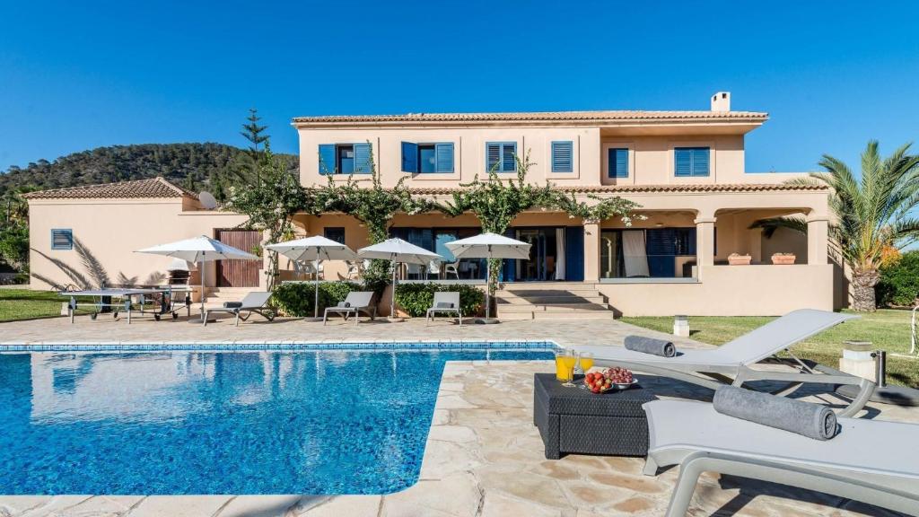 uma villa com uma piscina e uma casa em Villa Etruria close to Playa d'en Bossa em San Jose de sa Talaia