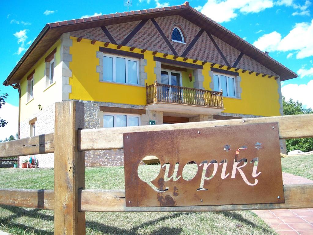 une maison jaune avec un panneau devant elle dans l'établissement Casa Rural Quopiki, à Gopegi