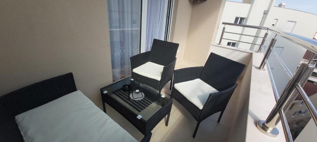 a balcony with two chairs and a bed and a table at Apartment Boki in Budva