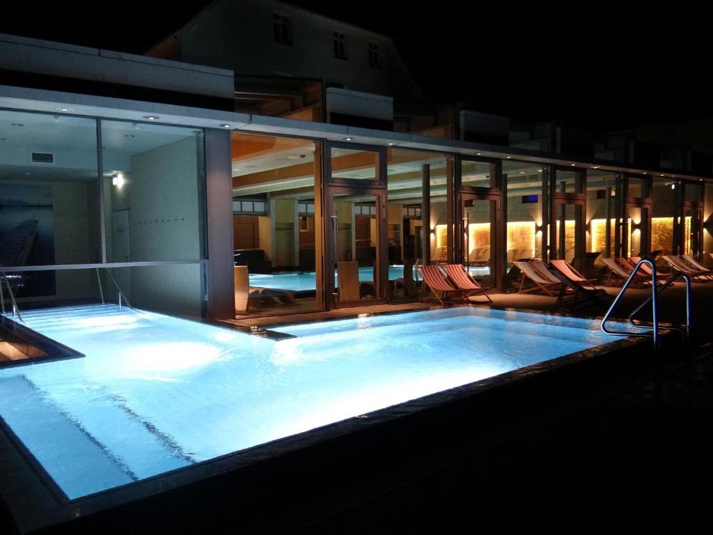 a large swimming pool with chairs in a building at Hotel und Restaurant Am Peenetal in Liepen