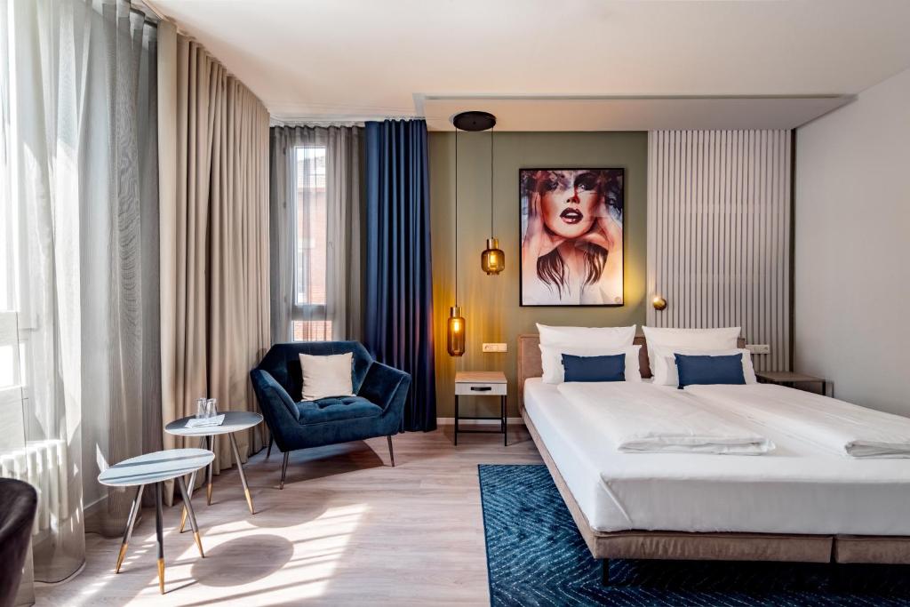 a hotel room with a bed and a chair at Aspire Elements Reutlingen, Trademark Collection by Wyndham in Reutlingen