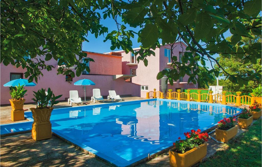 a swimming pool in front of a house at Nice Home In Valtursko Polje With Wifi And Outdoor Swimming Pool in Pula