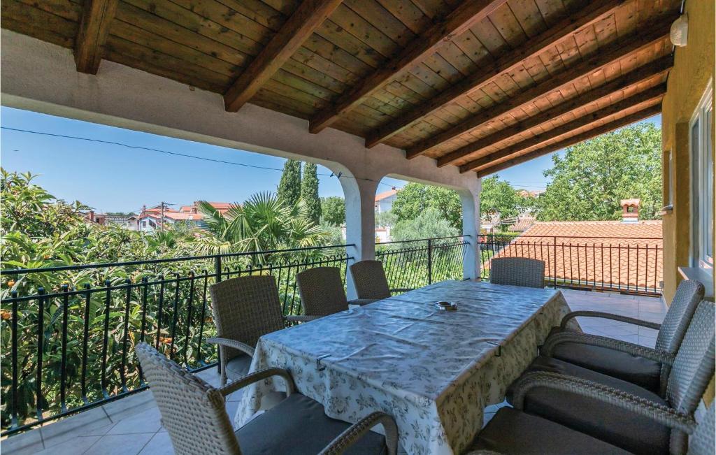 patio con mesa y sillas en el balcón en Beautiful Apartment In Rovinjsko Selo With 4 Bedrooms, en Rovinjsko Selo