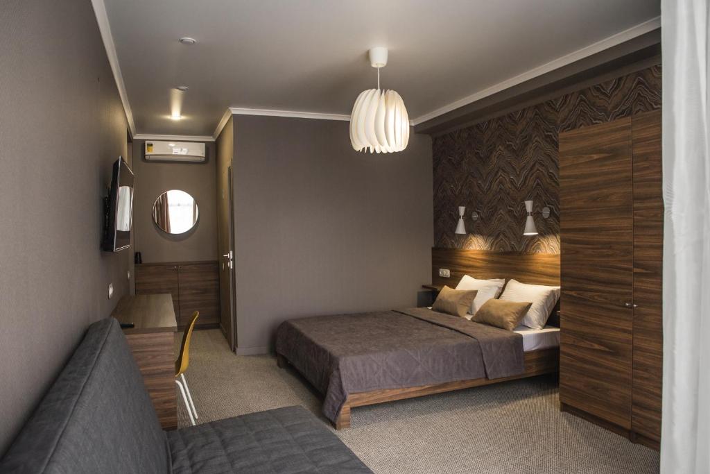 1 dormitorio con 1 cama y 1 sofá en Guest House Venezia, en Anapa