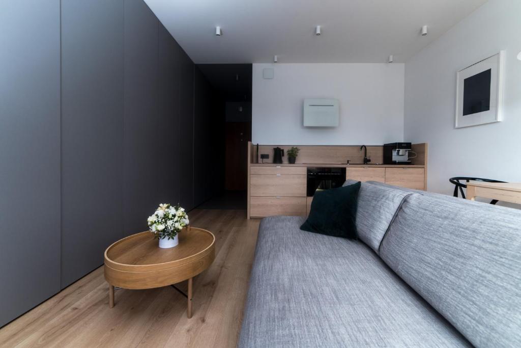 a living room with a couch and a table at Amelia by Q4Apartments in Gdańsk