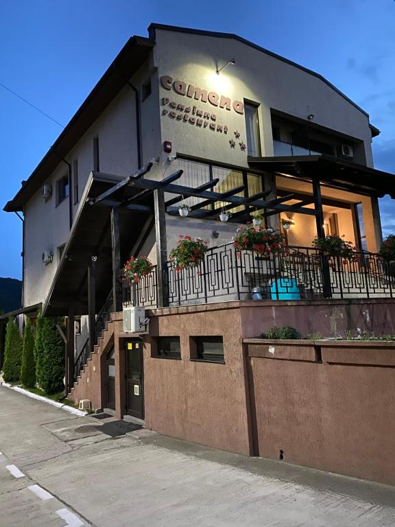 a building with a balcony with flowers on it at Pensiunea Camena in Piatra Neamţ