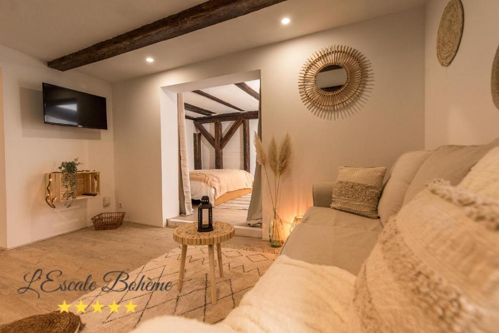 セレスタにあるL'Escale Bohème - Centre historique de Sélestatのソファと鏡のあるリビングルーム