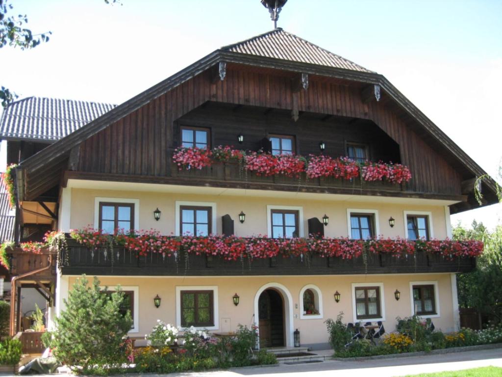 una casa con flores a un lado. en Hoferbauergut en Strobl