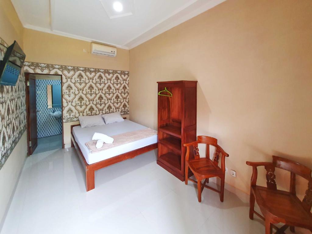 a small bedroom with a bed and a chair at Graha Adi Karya Syariah Kartasura RedPartner in Kartosuro