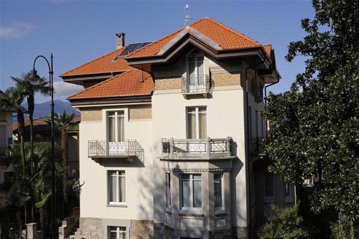 un grand bâtiment blanc avec un toit rouge dans l'établissement Residence Villa Maurice, à Stresa