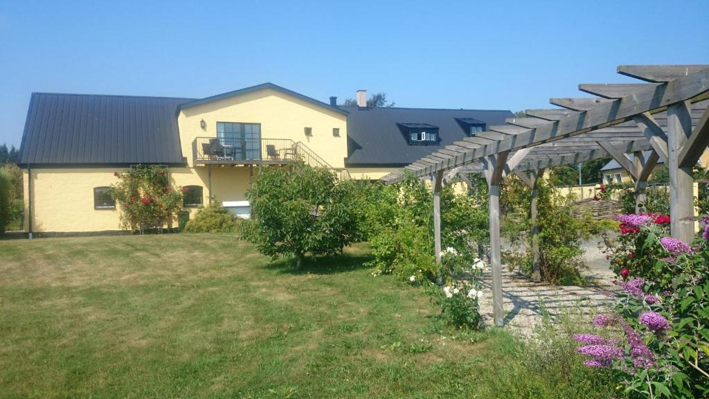 a garden with a pergola in front of a house at Branteviks Viste in Brantevik