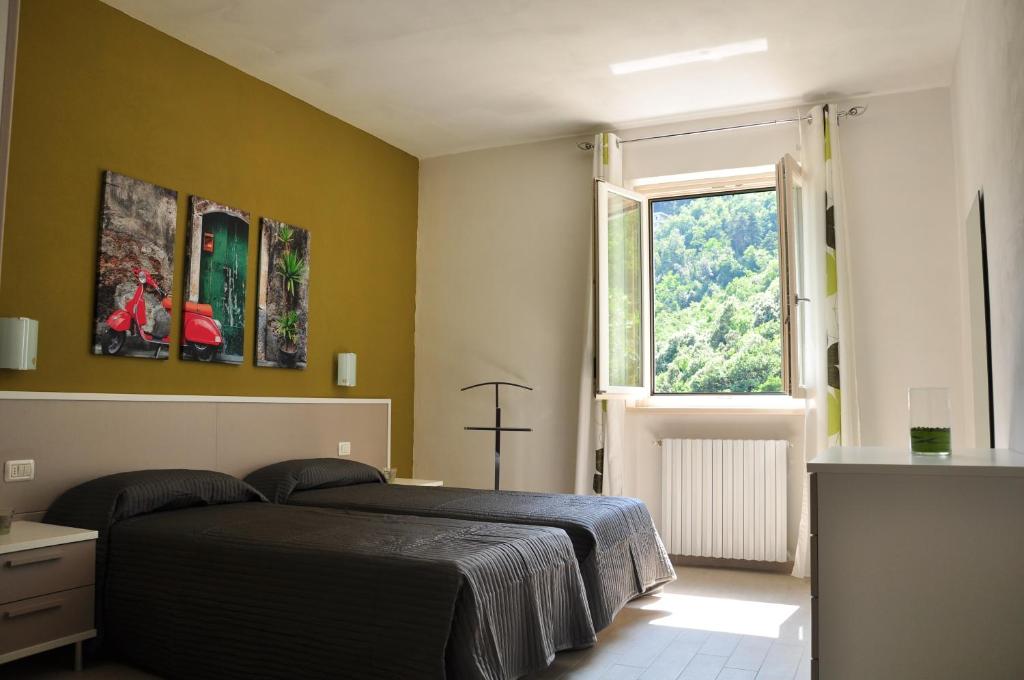 a bedroom with a black bed and a window at Casa Bine in Tremosine Sul Garda