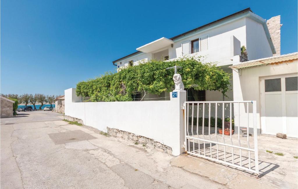 a white fence in front of a white house at Awesome Apartment In Razanac With Wifi in Ražanac