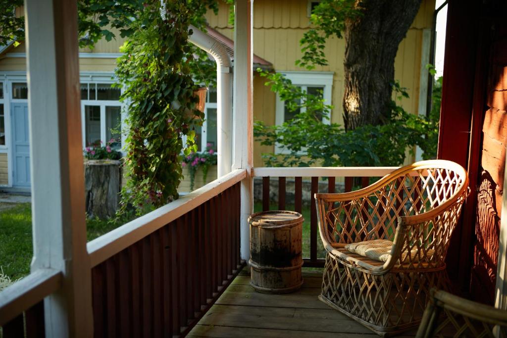 a porch with a chair and a trash can at Taattisten Tila - Taattinen Farm and Cottages in Naantali