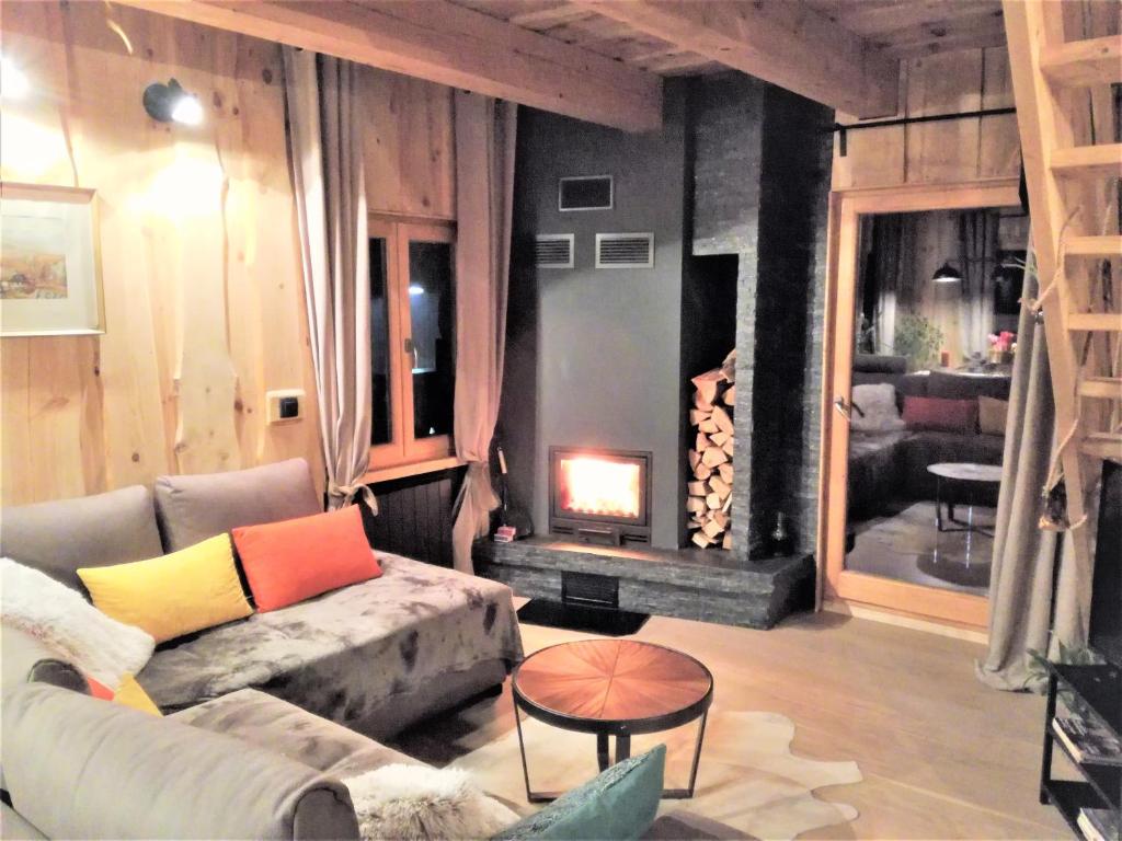 a living room with a couch and a fire place at LES CHALET Kranjska Gora DUPLEX in Kranjska Gora