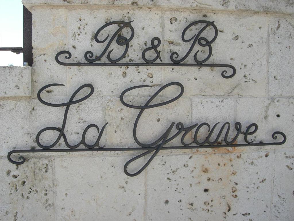 una señal que dice estar en casa en una pared de ladrillo en B&B La Grave, en Noci
