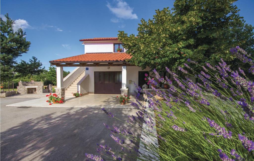 a house with purple flowers in front of a fence at Amazing Apartment In Pazin With 2 Bedrooms And Wifi in Katun Lindarski