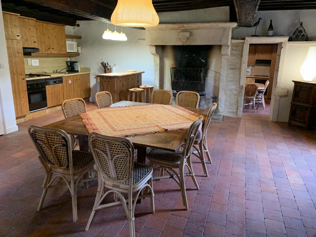 cocina y comedor con mesa y sillas en Les maisons vigneronnes, en Ozenay