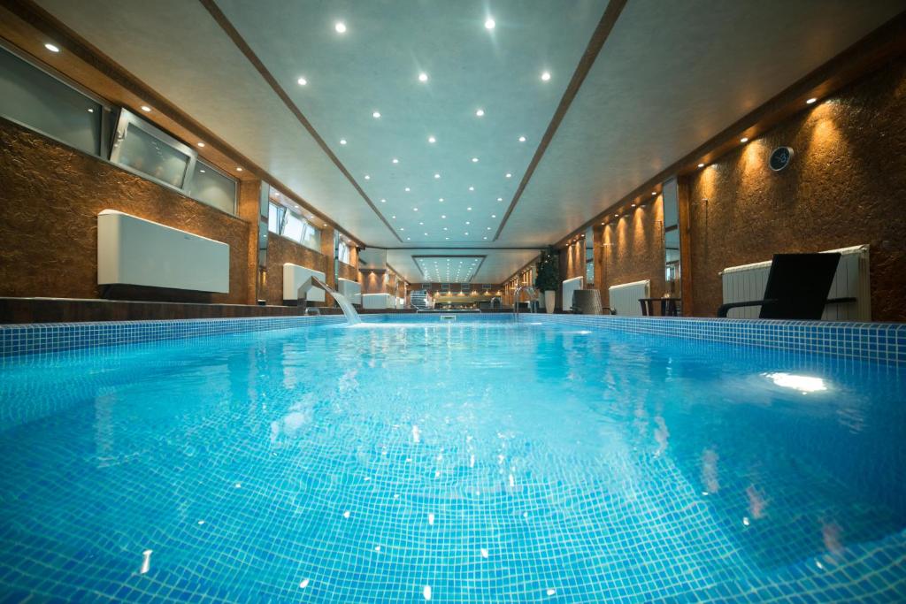 a large blue swimming pool in a building at Prezident Hotel in Novi Sad