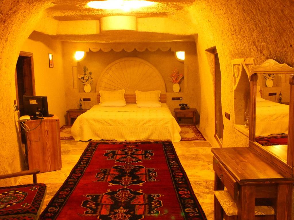 a bedroom with a large bed in a room at Dilek Tepesi Cave Hotel in Ayvalı