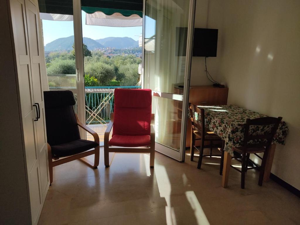 Zimmer mit einem Tisch und Stühlen sowie einem Balkon in der Unterkunft Casa Paggi in Lavagna