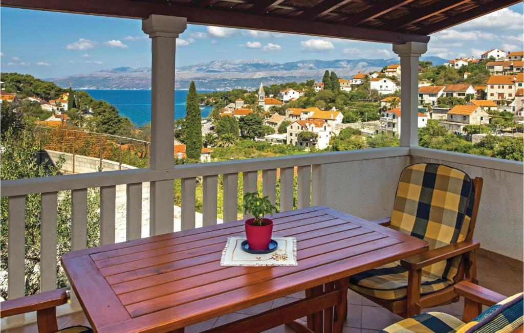 a wooden table and chairs on a balcony with a view at Nice Apartment In Splitska With Wifi in Splitska