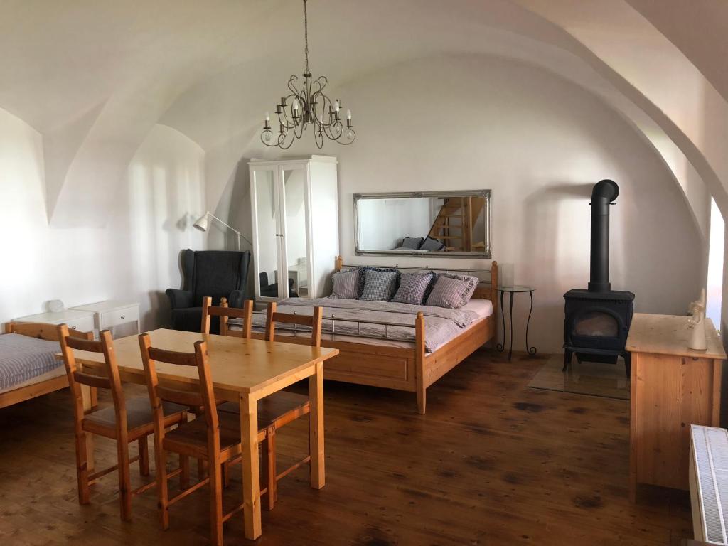 ein Wohnzimmer mit einem Sofa, einem Tisch und einem Herd in der Unterkunft Penzion a hospoda Na statku in Hluboká nad Vltavou