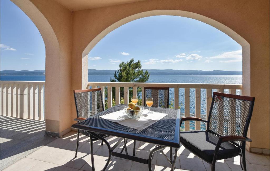 a table and chairs on a balcony with a view of the ocean at Gorgeous Apartment In Stanici With Kitchen in Čelina