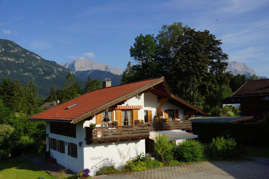 a white house with a red roof with mountains in the background at Ferienwohnung Soiernblick in Krün